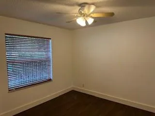 a view of a small space with wooden floor and a chandelier fan