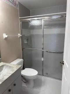 a bathroom with a granite countertop mirror vanity and toilet
