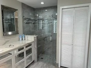 a bathroom with a shower sink and mirror