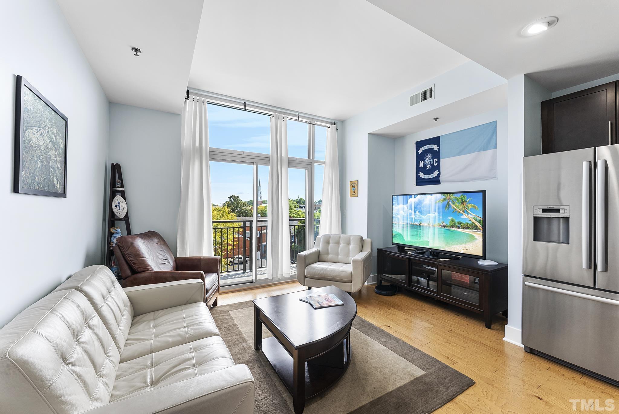 140 West Franklin Street, Unit 415 Chapel Hill, NC 27516 - Photo 12 of 29 a living room with furniture flat screen tv and a refrigerator