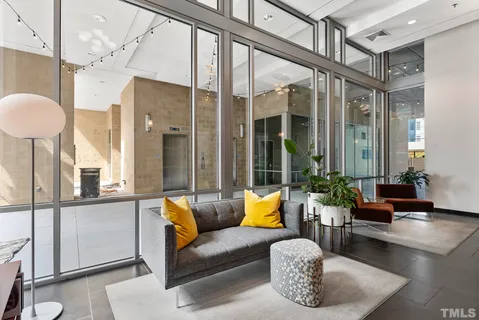 a living room with furniture a lamp and a large window