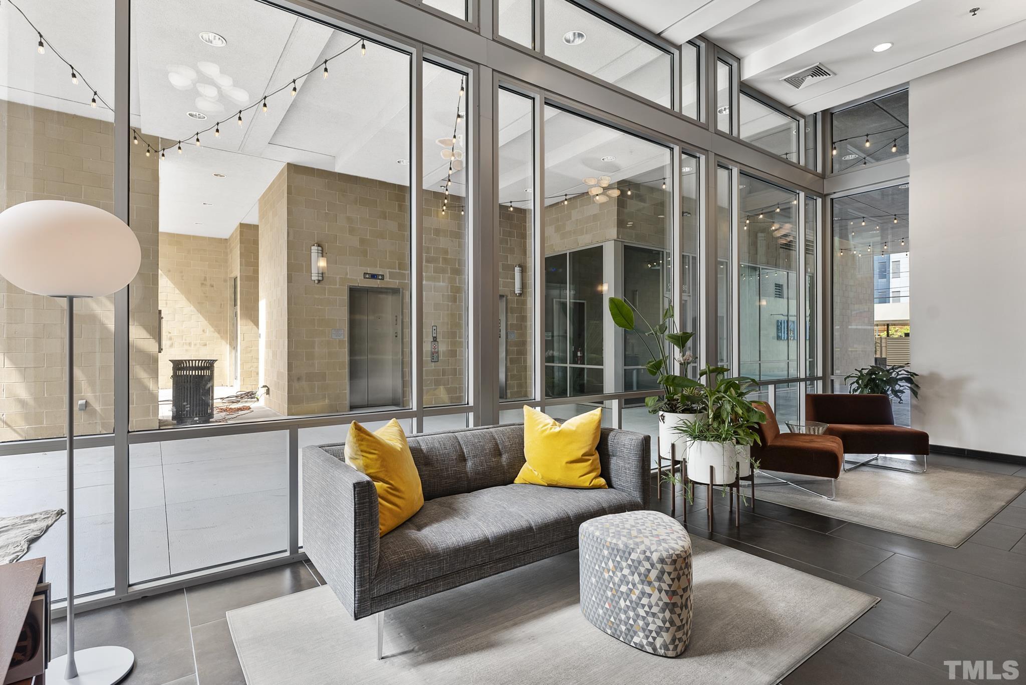 140 West Franklin Street, Unit 415 Chapel Hill, NC 27516 - Photo 15 of 29 a living room with furniture a lamp and a large window