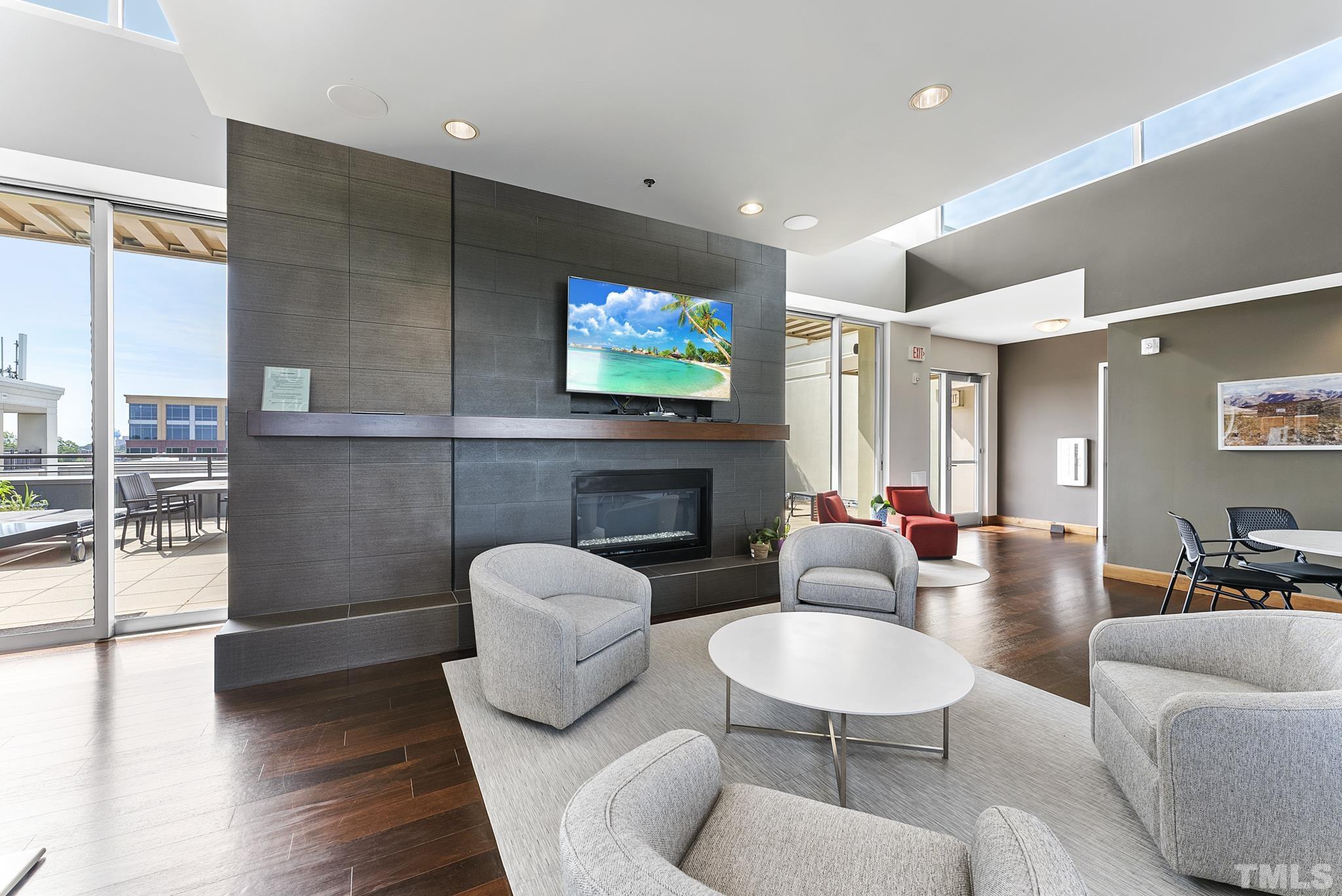 140 West Franklin Street, Unit 415 Chapel Hill, NC 27516 - Photo 22 of 29 a living room with furniture a fireplace and a flat screen tv