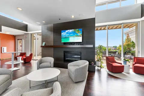 a living room with furniture a flat screen tv and a large window