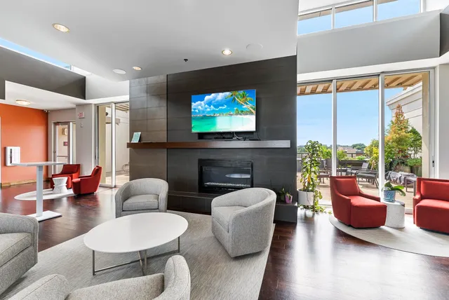 a living room with furniture a flat screen tv and a large window