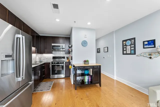 a kitchen with stainless steel appliances a refrigerator and a stove top oven