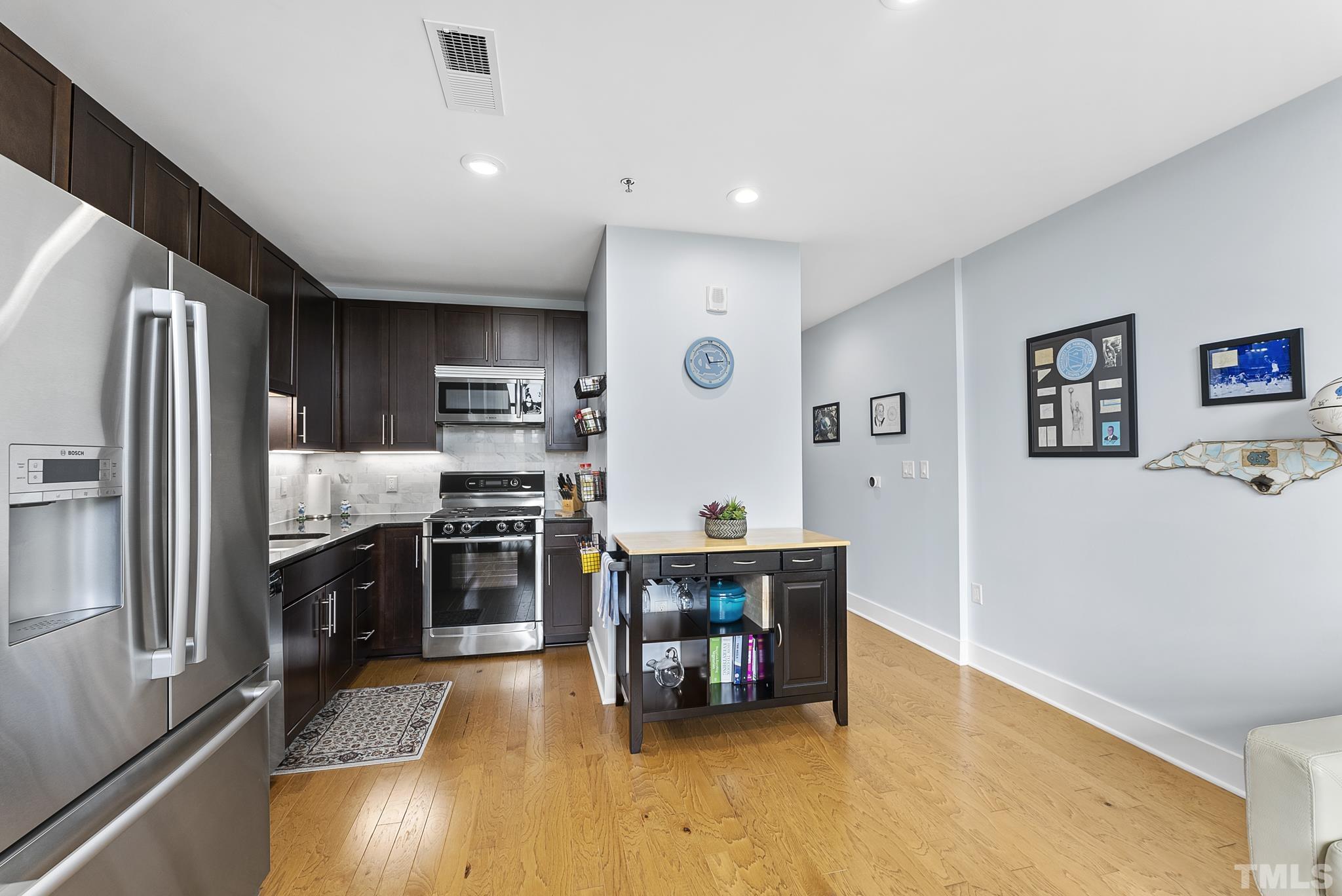 140 West Franklin Street, Unit 415 Chapel Hill, NC 27516 - Photo 3 of 29 a kitchen with stainless steel appliances a refrigerator and a stove top oven