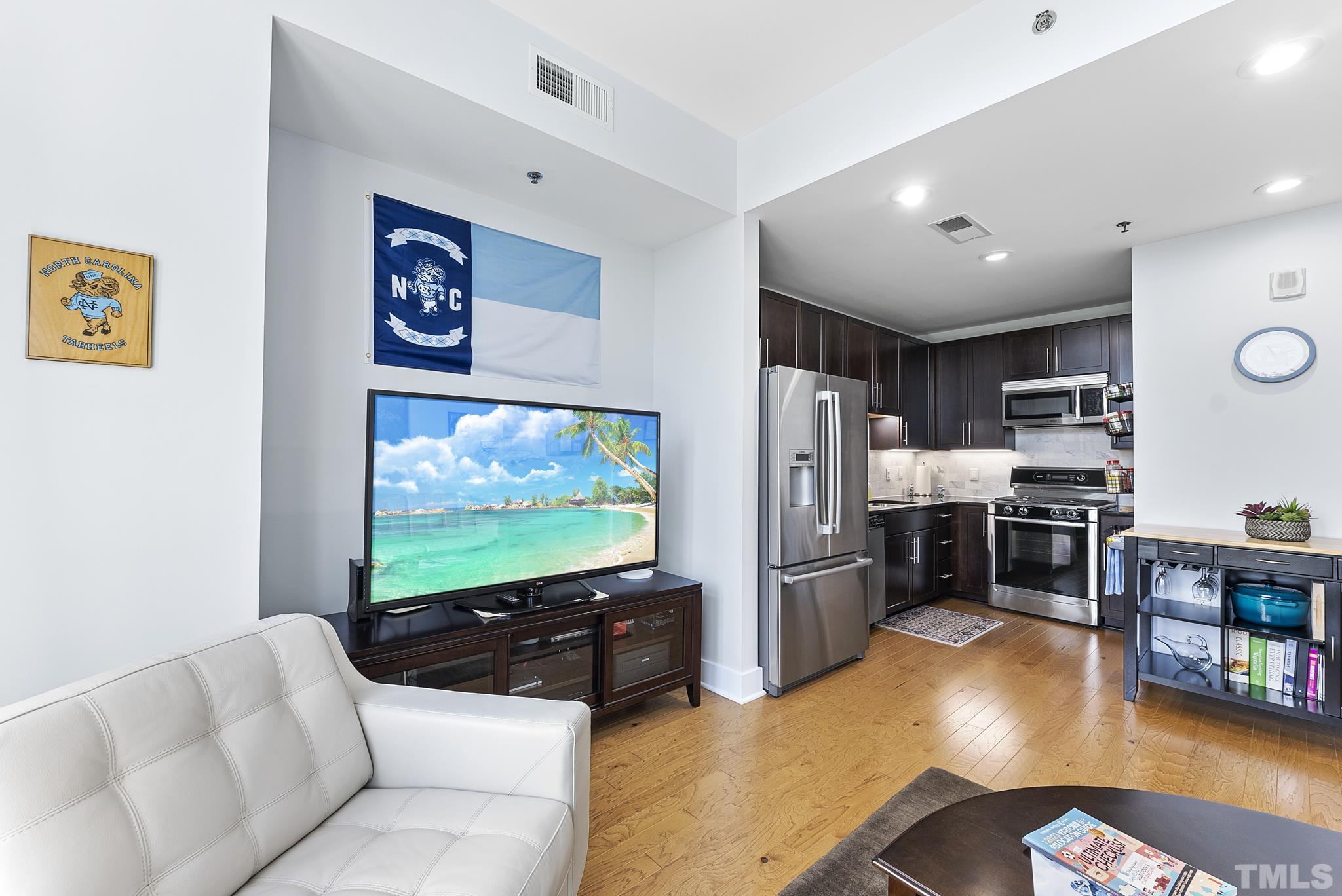 140 West Franklin Street, Unit 415 Chapel Hill, NC 27516 - Photo 4 of 29 a living room with stainless steel appliances furniture and a flat screen tv