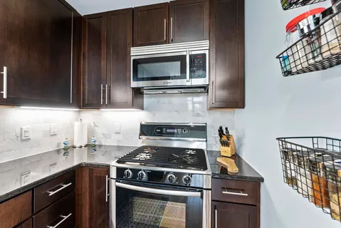a kitchen with granite countertop a stove and a microwave