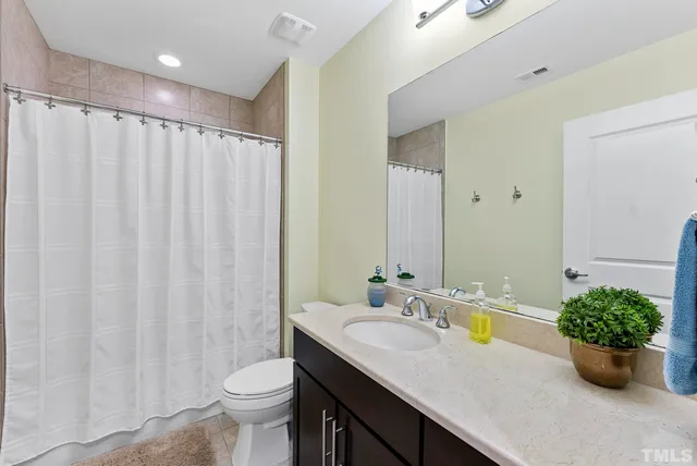 a bathroom with a granite countertop sink a toilet and a shower
