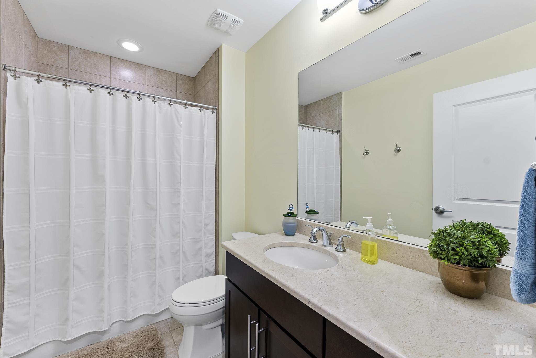 140 West Franklin Street, Unit 415 Chapel Hill, NC 27516 - Photo 9 of 29 a bathroom with a granite countertop sink a toilet and a shower