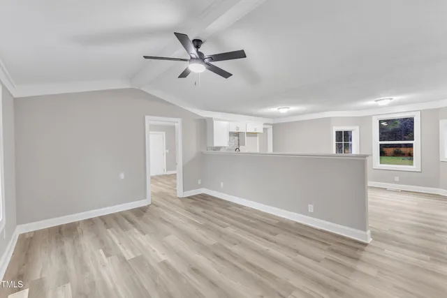 a view of a livingroom with wooden floor and a ceiling fan