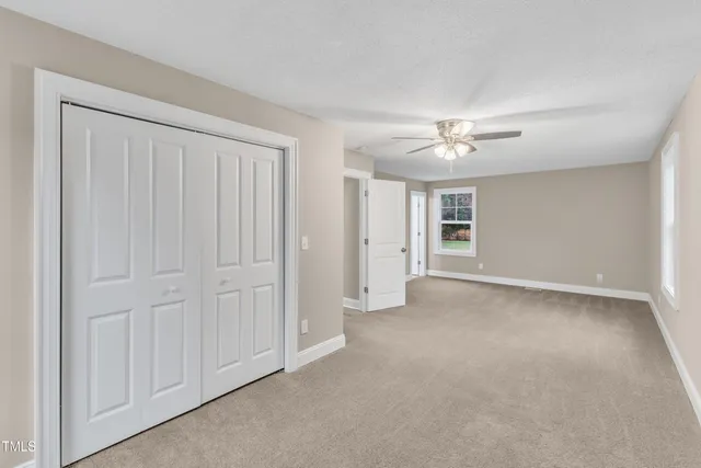 an empty room with a ceiling fan and a window