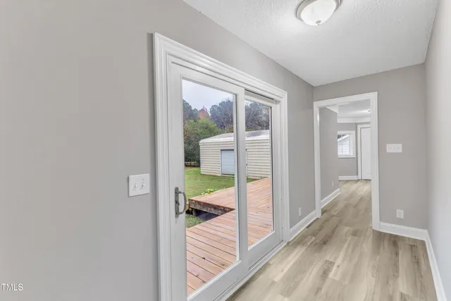 a view of a hallway with bathroom and wooden floor