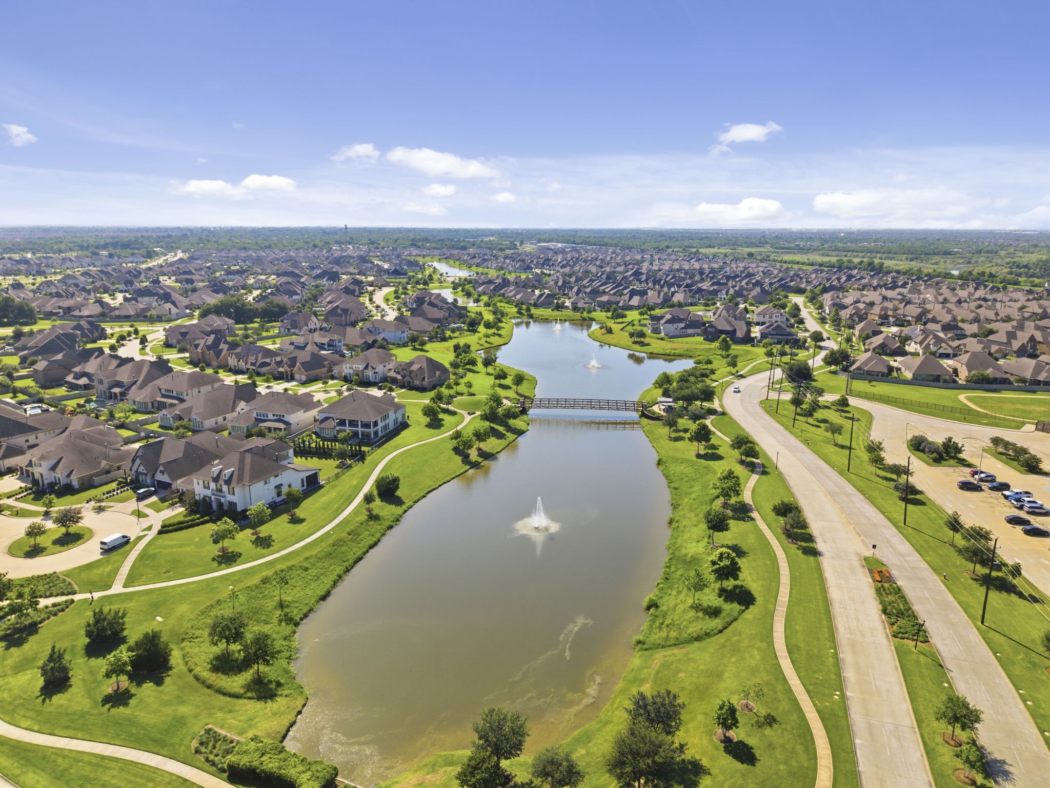 2119 Blackhawk Ridge Lane Manvel, TX 77578 - Photo 48 of 49 Breathtaking aerial view of Pomona's scenic lake system, winding waterways, lush green parks, and pedestrian bridges — showcasing the thoughtful master-planned design that makes Pomona one of the most sought-after communities in Brazoria County.