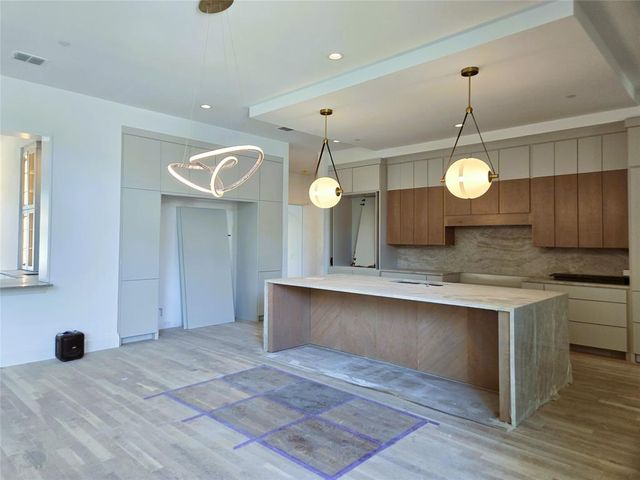 a view of a kitchen with a sink a chandelier and wooden floor