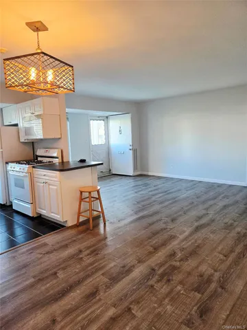 a kitchen with granite countertop a stove a sink and a wooden cabinets