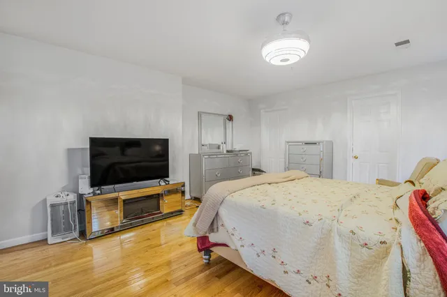 a spacious bedroom with a bed and a flat screen tv