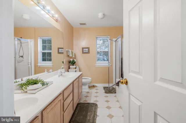 a bathroom with a granite countertop sink a mirror and shower
