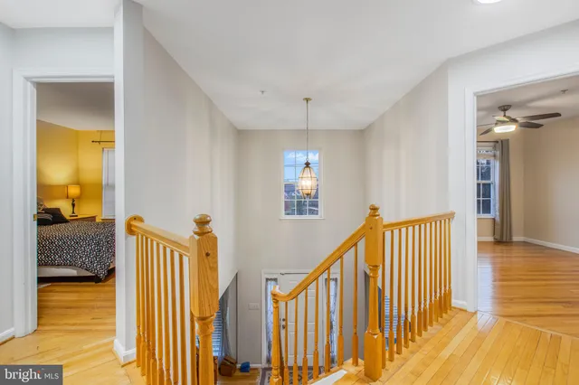 a view of a hallway with wooden floor and staircase