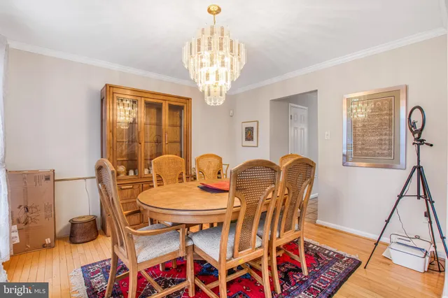 a dining room with furniture a chandelier and wooden floor