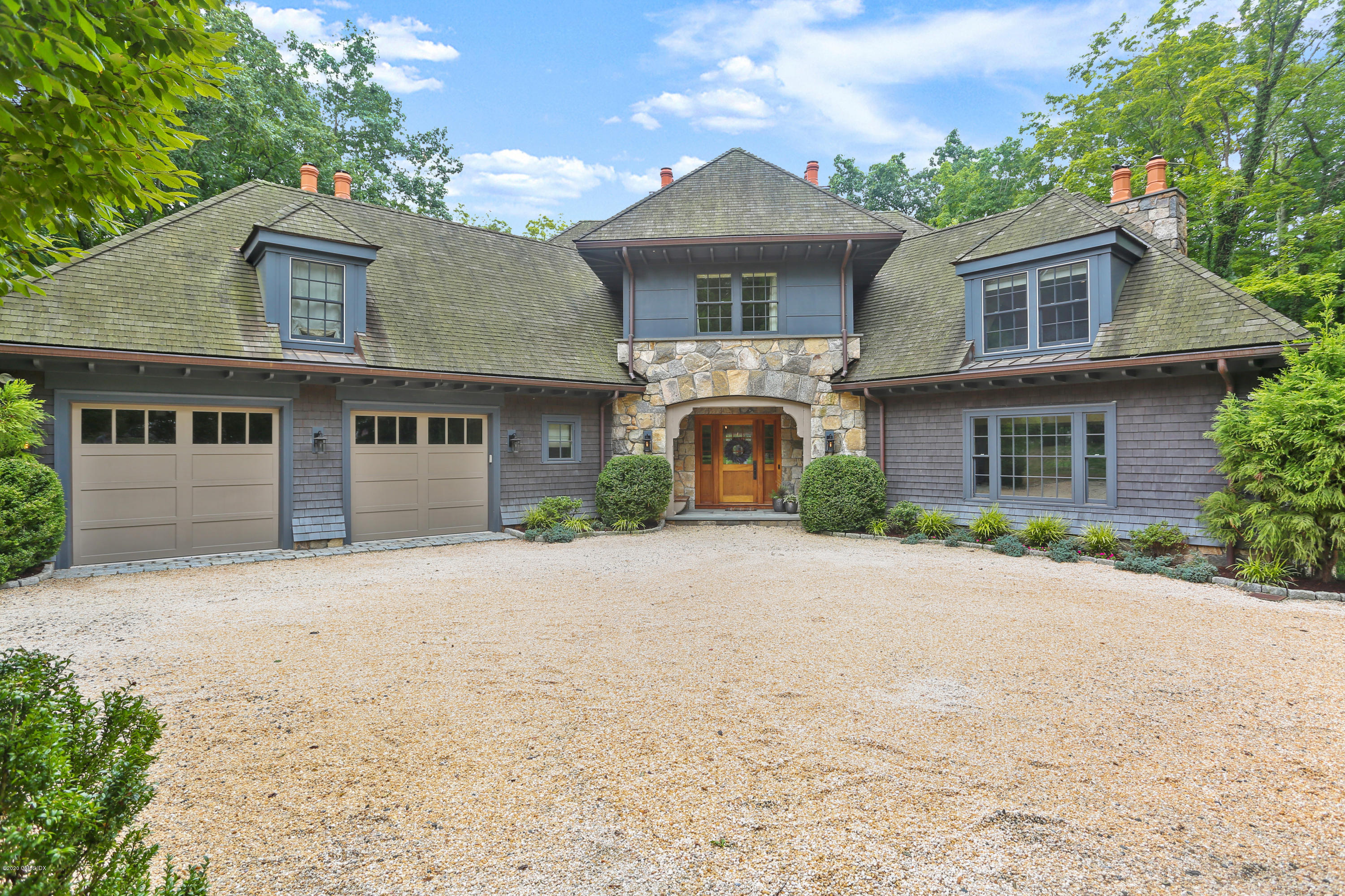 125 Cat Rock Road Cos Cob, CT 06807 - Photo 23 of 33 a front view of a house with a yard and garage
