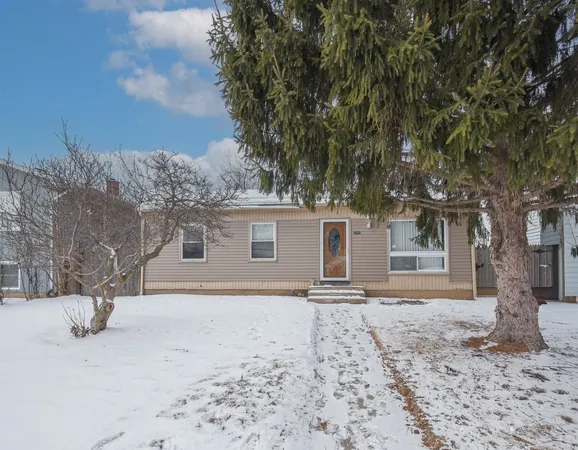 a front view of a house with a yard covered in snow