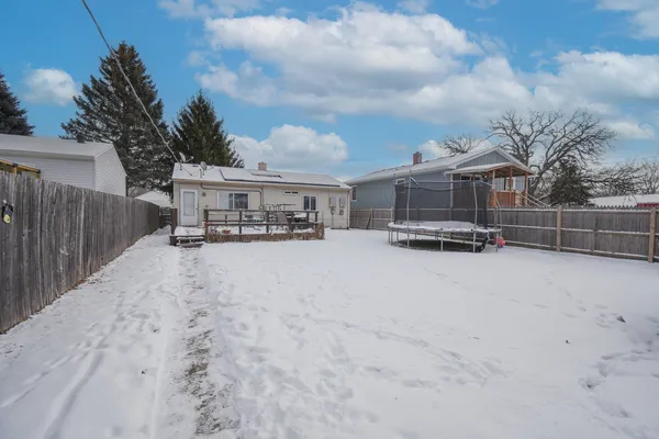 a view of a house with a yard and wooden fence