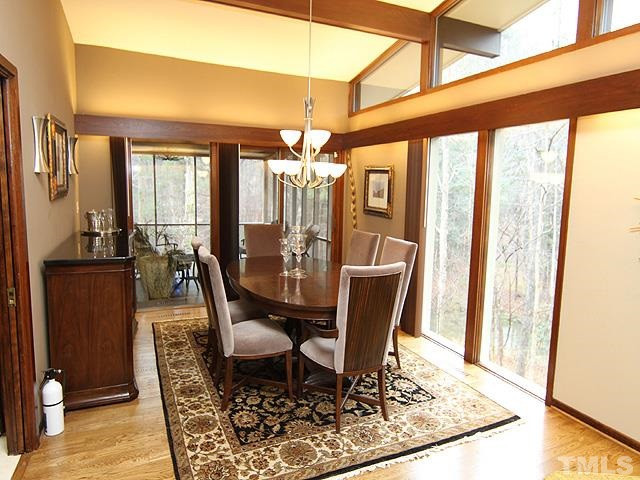 4901 Rembert Drive Raleigh, NC 27612 - Photo 6 of 25 A elegant dining area overlooking the screened porch and natural wooded lot, floor to ceiling windows, wall sconce lighting, hardwood floors, mounted wall lighting. Dining Room