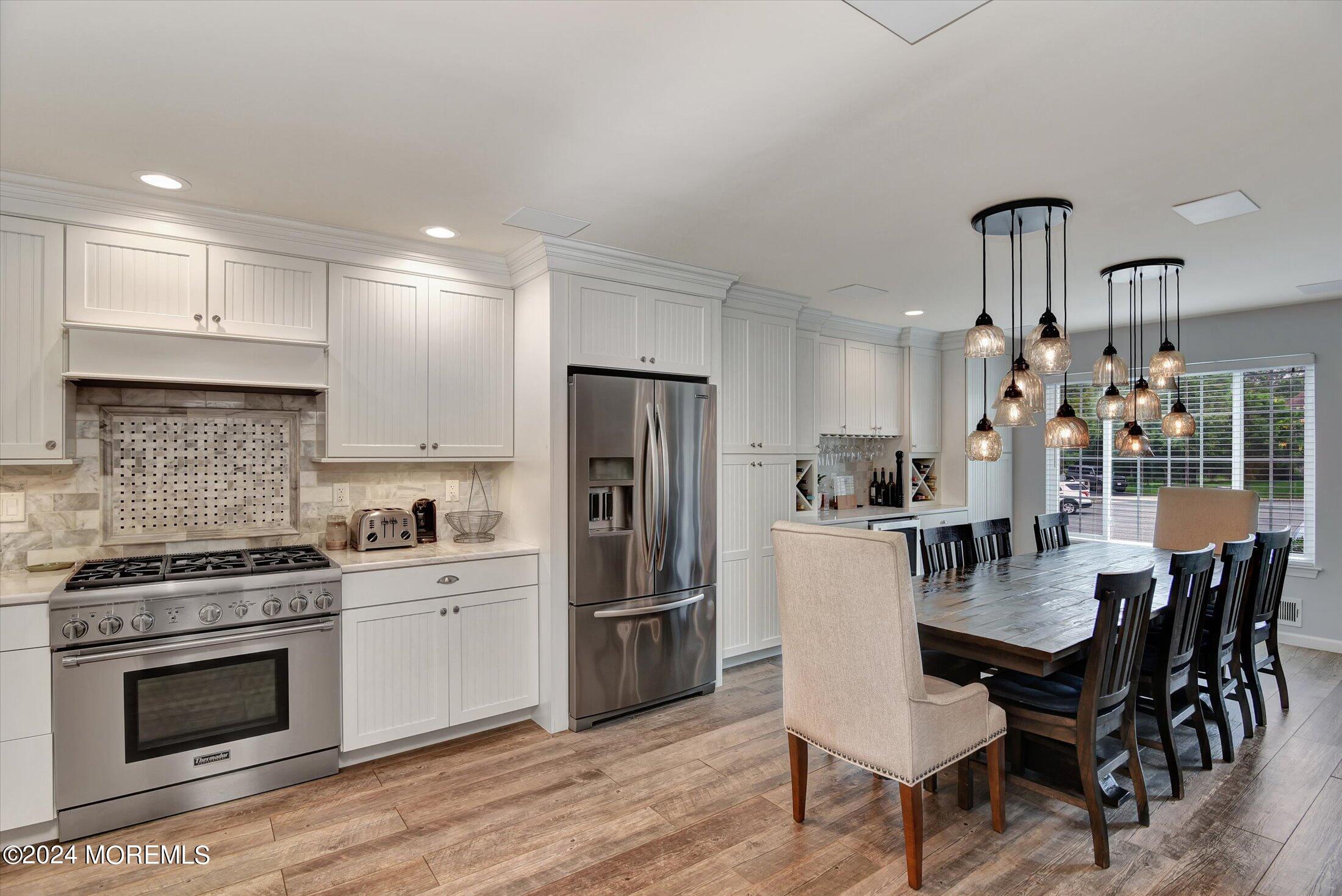 29 Nate Lane Howell, NJ 07731 - Photo 12 of 42 a kitchen with refrigerator cabinets dining table and chairs