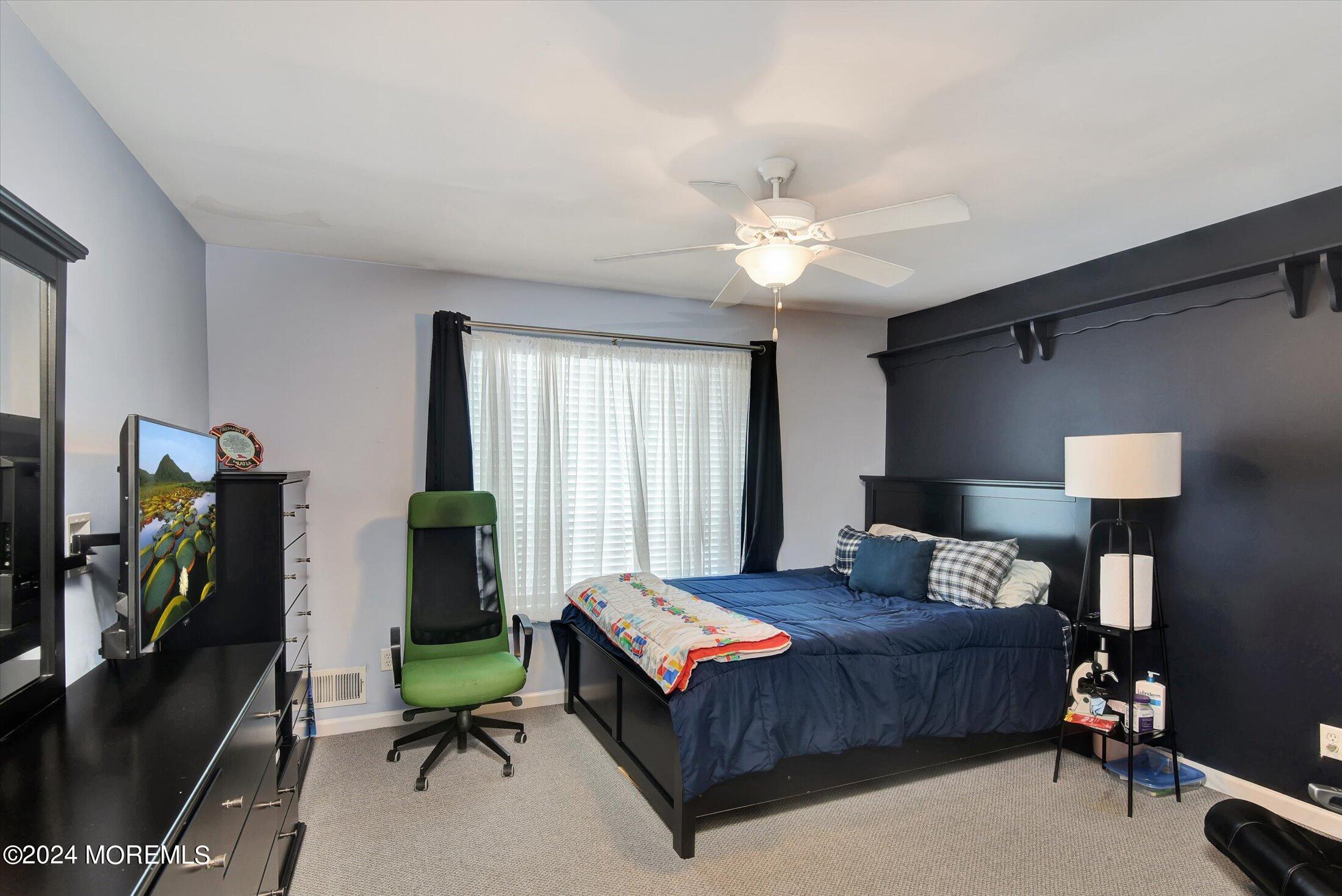 29 Nate Lane Howell, NJ 07731 - Photo 19 of 42 a bedroom with a bed and a chandelier