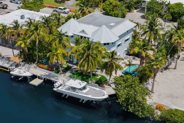 an aerial view of a house with a yard and lake view