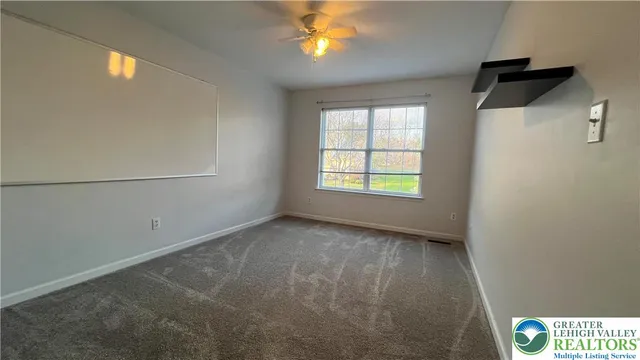 a view of an empty room with closet and a chandelier fan