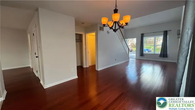 a view of a livingroom with wooden floor and a chandelier