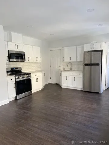 a kitchen with a refrigerator and a stove top oven