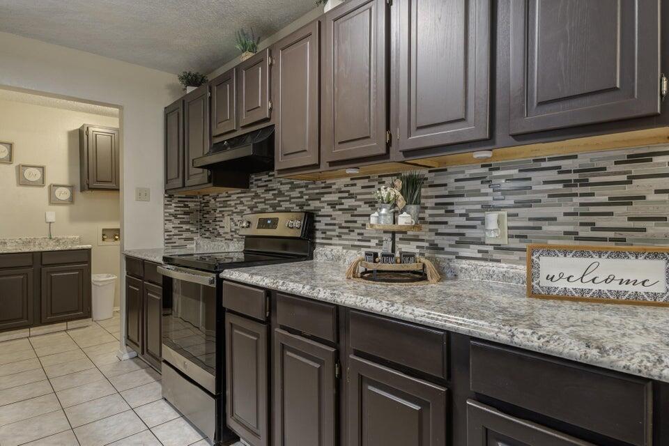 3401 101st Street Lubbock, TX 79423 - Photo 15 of 28 a kitchen with stainless steel appliances granite countertop a sink stove and cabinets