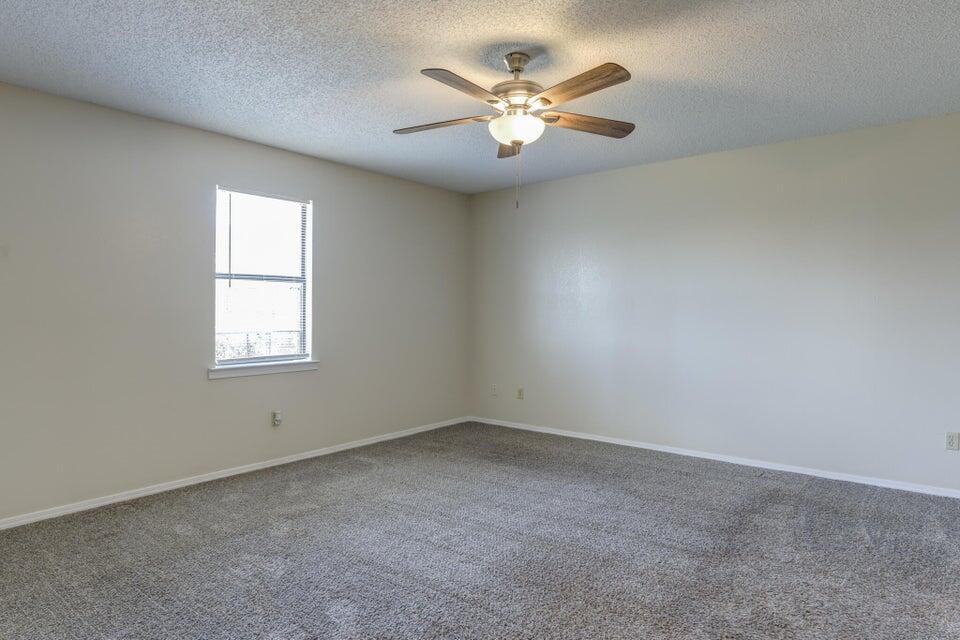 3401 101st Street Lubbock, TX 79423 - Photo 19 of 28 an empty room with windows and fan