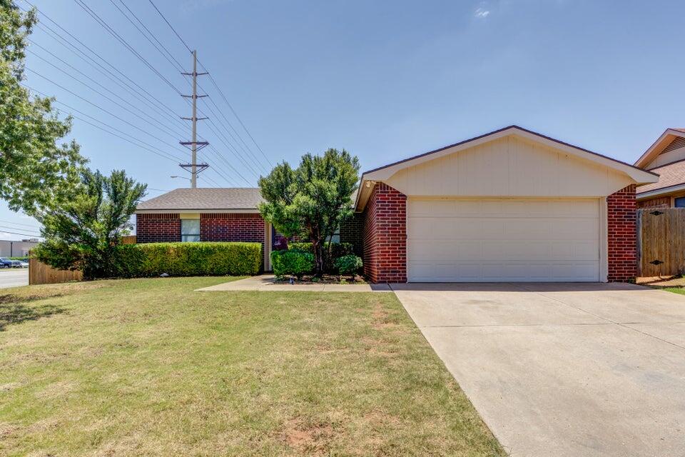 3401 101st Street Lubbock, TX 79423 - Photo 2 of 28 a front view of a house with a yard and garage