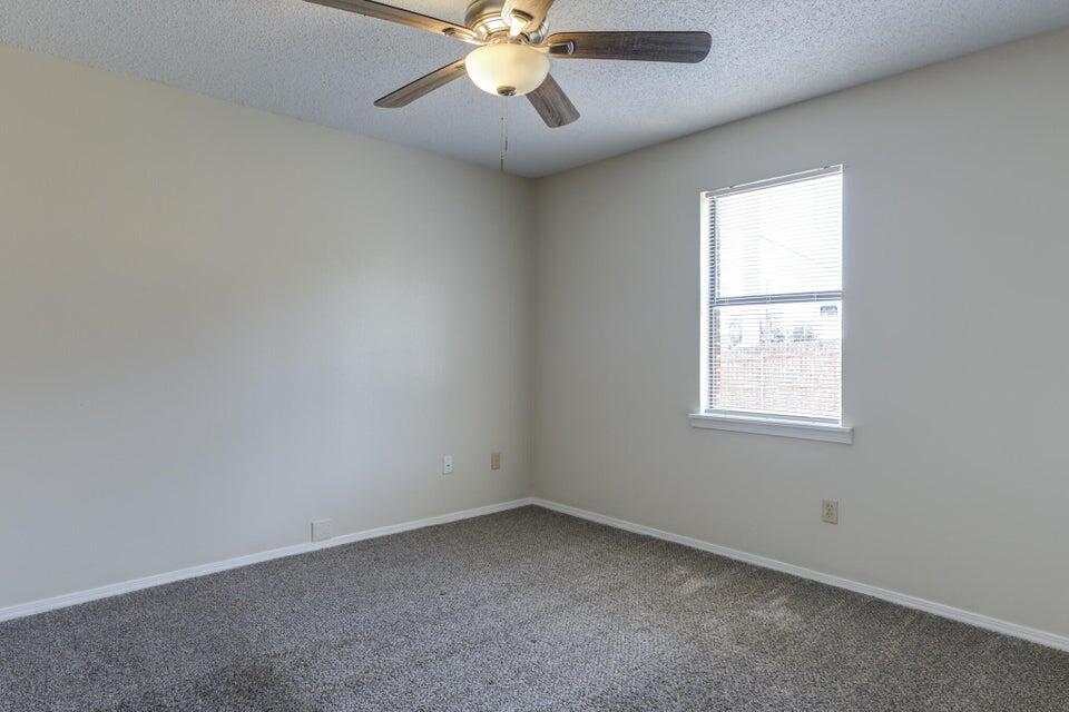 3401 101st Street Lubbock, TX 79423 - Photo 23 of 28 an empty room with a window and a fan