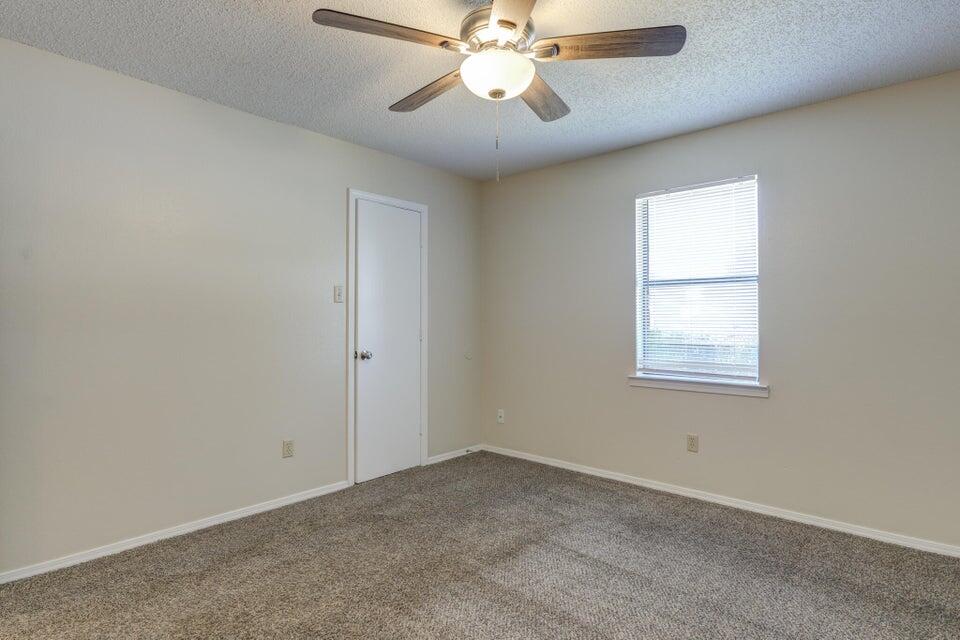 3401 101st Street Lubbock, TX 79423 - Photo 25 of 28 an empty room with a window and a fan