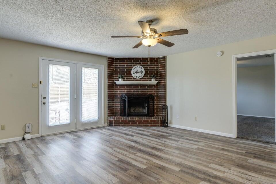 3401 101st Street Lubbock, TX 79423 - Photo 5 of 28 a view of an empty room with wooden floor fireplace and a window
