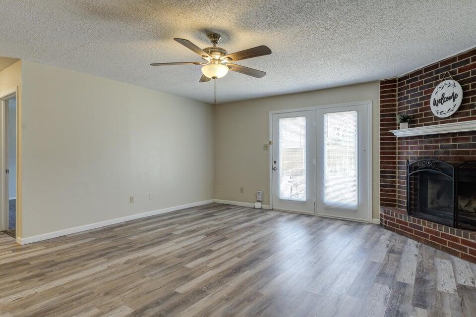 3401 101st Street Lubbock, TX 79423 - Photo 6 of 28 a view of an empty room with wooden floor and a window