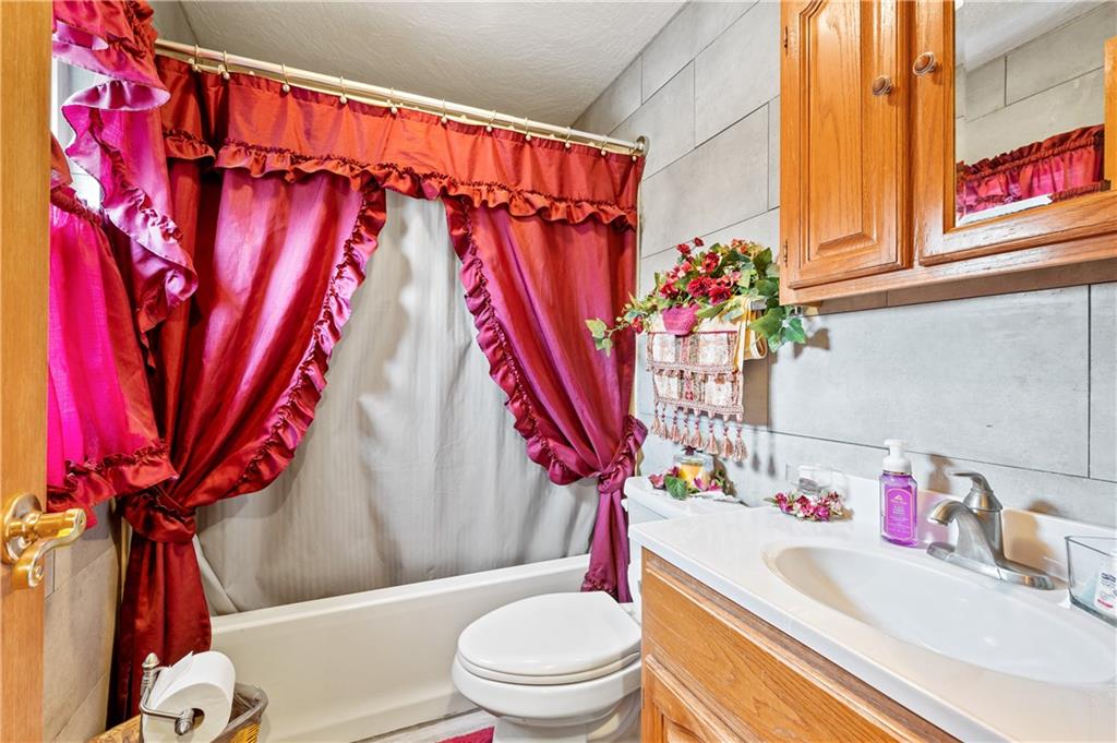 1027 Fiddleback Drive McKees Rocks, PA 15136 - Photo 13 of 25 a bathroom with a sink a toilet and shower curtain