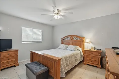 a bedroom with a bed and a tv on the dresser