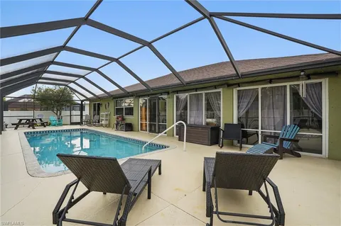 a view of a patio with table and chairs and barbeque