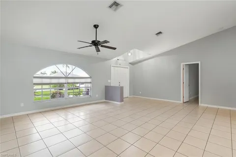 an empty room with windows and fan