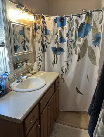 a bathroom with a sink and mirror with bathtub