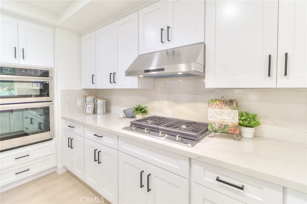 2225 Terraza Place Fullerton, CA 92835 - Photo 24 of 73 a kitchen with white cabinets and appliances