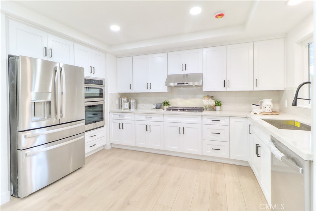 2225 Terraza Place Fullerton, CA 92835 - Photo 28 of 73 a kitchen with stainless steel appliances white cabinets and a refrigerator