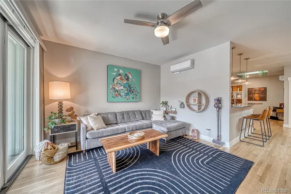 a living room with furniture a clock on wall and a window